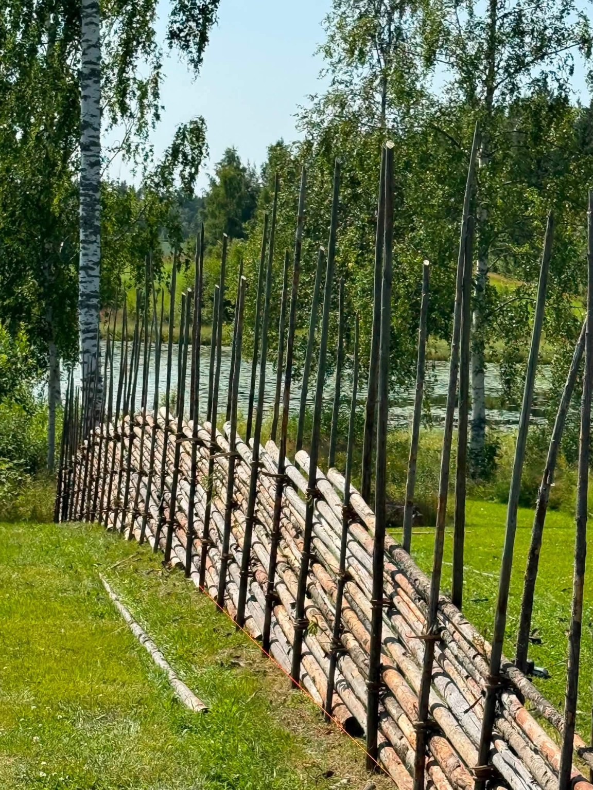 Lång gärdsgård vid vatten och grönska